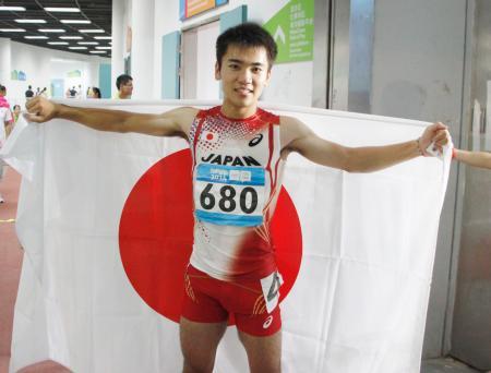 　陸上男子１００メートルで銀メダルを獲得し、日の丸を掲げる大嶋健太＝南京（共同）