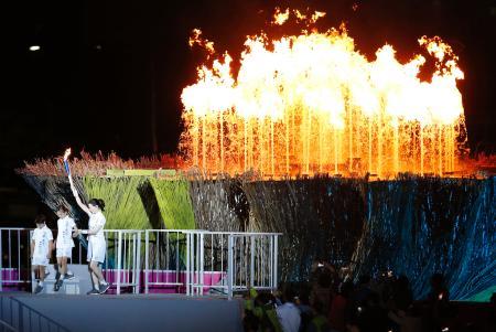 　点火された仁川アジア大会の聖火台。左下は点火者の女優イ・ヨンエさんと少年、少女＝１９日、韓国・仁川（共同）
