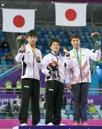 　男子個人総合で金メダルを獲得し、表彰台で笑顔を見せる神本雄也（中央）