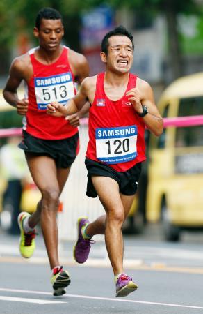 　男子マラソン　中間地点を過ぎた付近で苦しそうな表情のカンボジア代表の猫ひろし（右）＝仁川（共同）