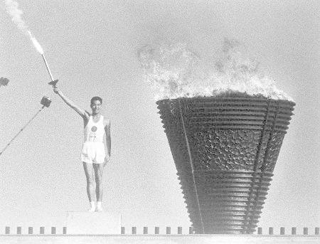 　１９６４年の東京五輪開会式で、聖火台に点火し、トーチを掲げる坂井義則さん＝国立競技場
