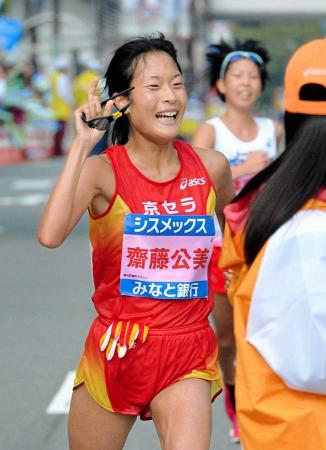 　女子フルマラソンで優勝を確信し、ガッツポーズする斎藤公美。右後方は２位の石本里緒奈（撮影・後藤亮平）