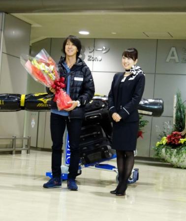 帰国し花束を受け取る葛西紀明（左）成田空港