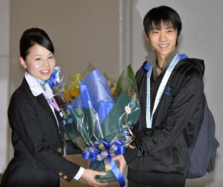 　バルセロナから帰国し、花束を受け取るフィギュアスケートの羽生結弦＝１６日午後、成田空港