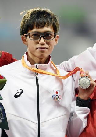 　仁川アジア大会の陸上男子１万メートルで２位となり、銀メダルを掲げる大迫傑（共同）