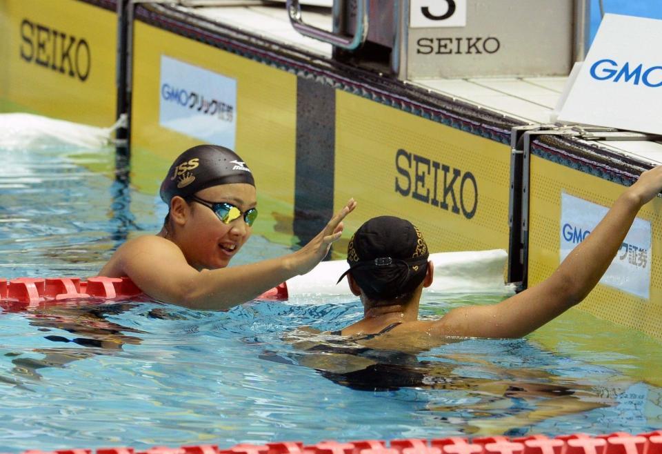 女子２００メートル平泳ぎで優勝し、４冠の渡部香生子（左）