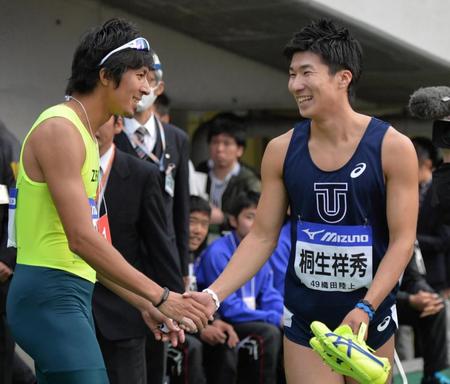 　走り終え藤光謙司（左）と握手する桐生祥秀
