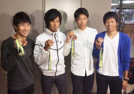 　陸上の世界リレー大会で獲得したメダルを掲げる（左から）桐生祥秀、藤光謙司、谷口耕太郎、大瀬戸一馬＝６日、成田空港