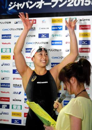 女子50メートル平泳ぎで日本新をマークし、笑顔で手を振る鈴木聡美