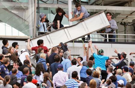 　錦織圭の試合中、観客席に落下した金属製の板を片付ける人たち＝パリ（ＡＰ＝共同）