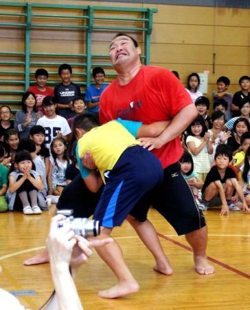 　子どもとの相撲で必死の形相で寄りを残す振分親方