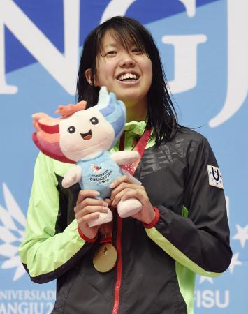 　女子１００メートル平泳ぎで優勝し、表彰台で笑顔の松島美菜＝光州（共同）