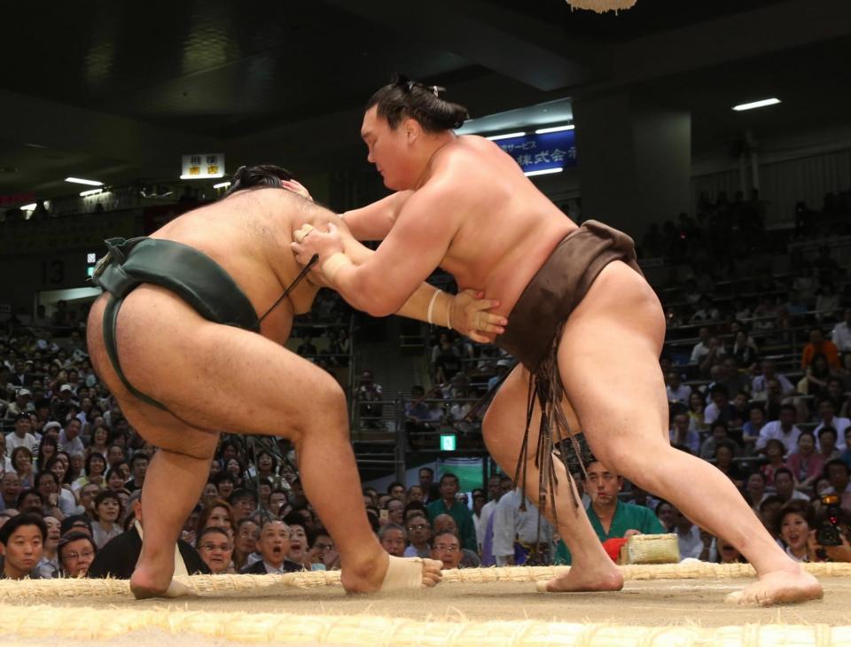 　高安（左）を送り出しで下す白鵬＝愛知県体育館