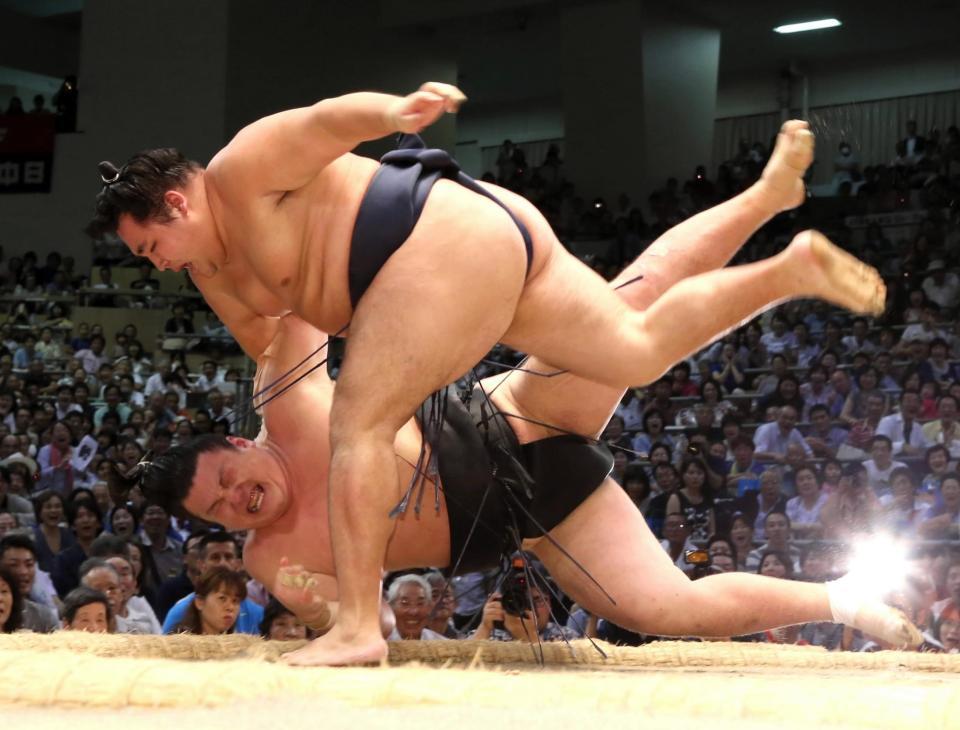 勢（下）を上手投げで下す鶴竜＝愛知県体育館