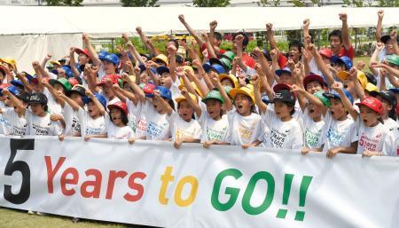 　東京五輪の開催まで５年となり、カウントダウンイベントで記念写真に納まる参加者ら＝２４日午前、東京都江東区