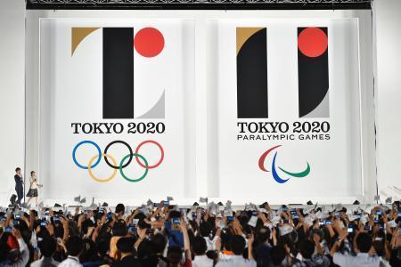 　東京都庁舎前で開かれたイベントで発表された、２０２０年東京五輪（左）とパラリンピックの公式エンブレム＝２４日夜