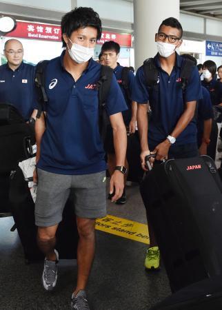 　陸上世界選手権に出場するため、マスクを着用して北京国際空港に到着した男子主将の藤光謙司（左）とサニブラウン・ハキーム＝２０日（共同）