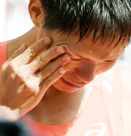 　男子２０キロ競歩で途中棄権し、涙を拭きながら引き揚げる鈴木雄介（共同）