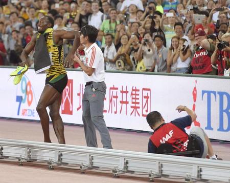 　転倒したカメラマン（右下）とウサイン・ボルト＝北京（共同）