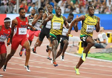 　男子４００メートルリレー決勝　第３走者からバトンを受け走りだす、ジャマイカアンカーのウサイン・ボルト（右端）＝共同
