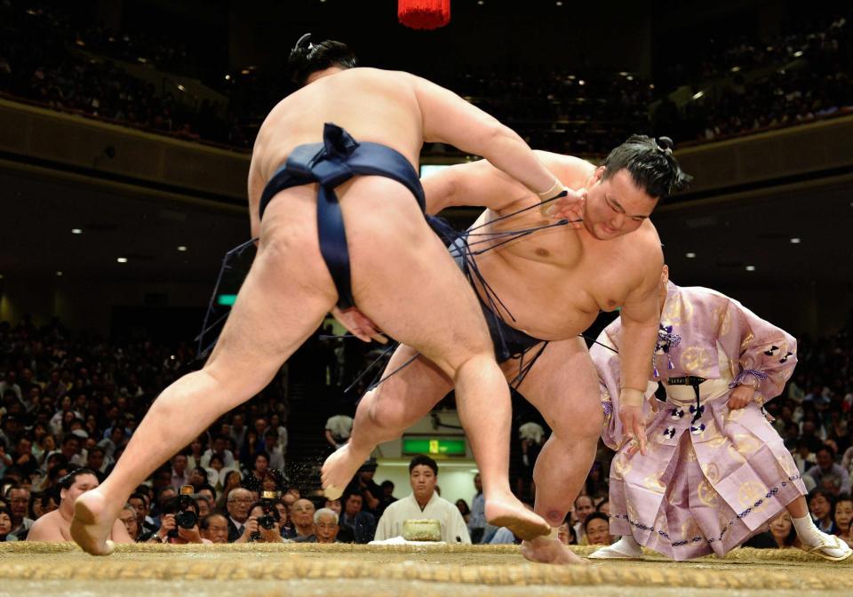 　やり直しの立ち合いで鶴竜（左）が左に変化し体勢を崩される稀勢の里