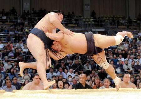 妙義龍（右）は鶴竜を土俵外へ押し出す＝福岡国際センター（撮影・保田叔久）