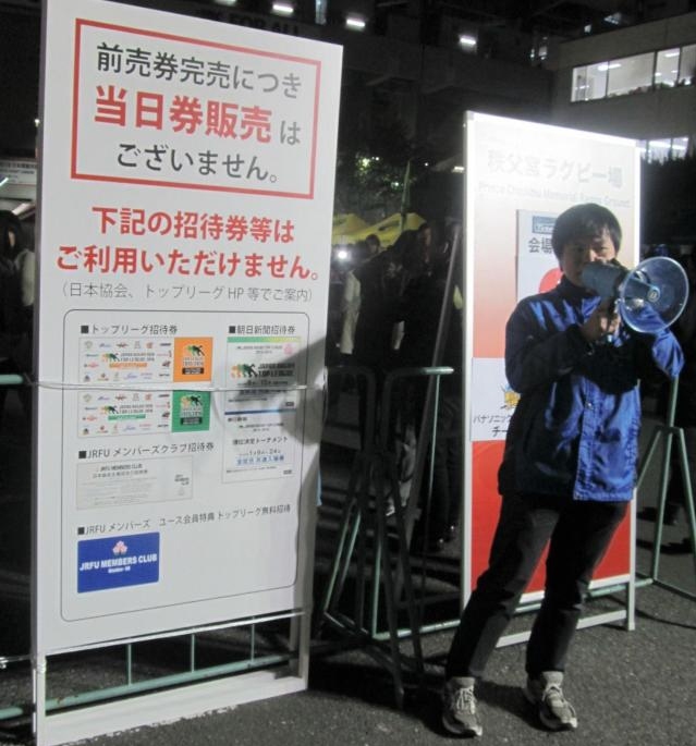ラグビートップリーグ開幕戦の当日券販売がないことを呼びかける係員＝秩父宮ラグビー場
