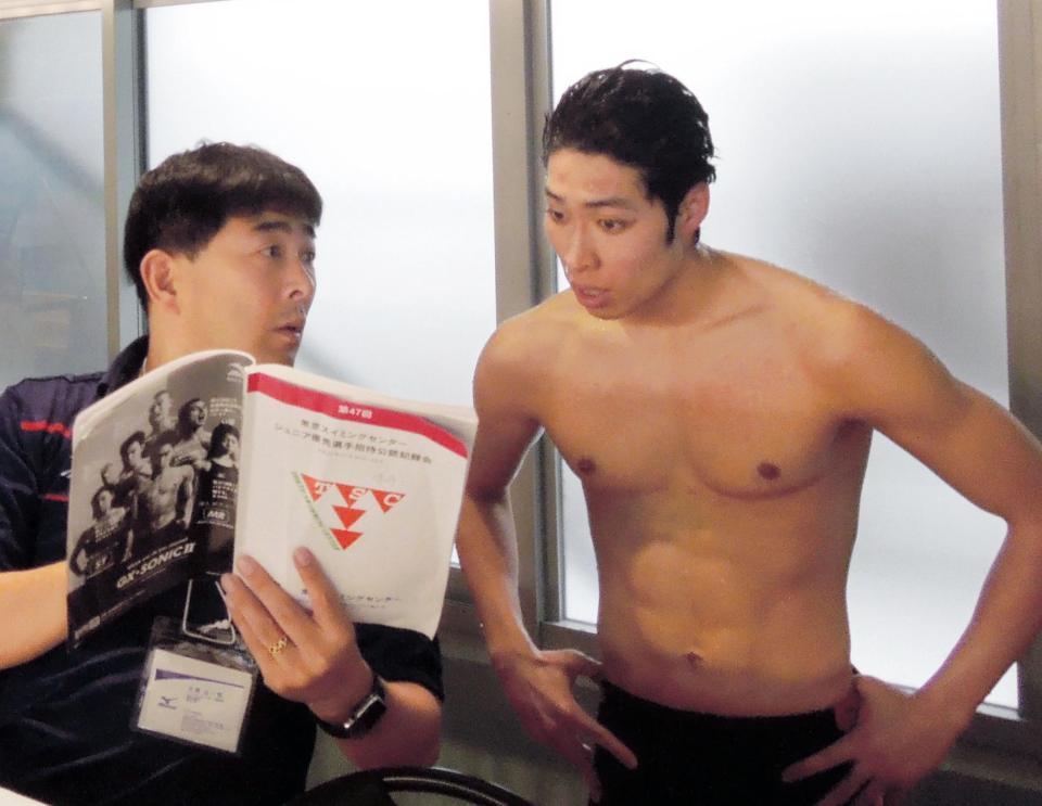 レースを終え、平井コーチ（左）と話し込む萩野公介