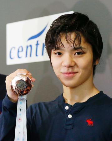 　グランプリファイナルから帰国し、メダルを見せる宇野昌磨＝１５日午前、中部空港