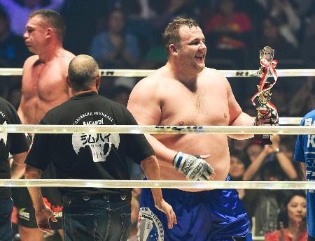 　「バルト」のリングネームで総合格闘技デビュー戦に勝利し、笑顔の把瑠都。左はピーター・アーツ＝さいたまスーパーアリーナ