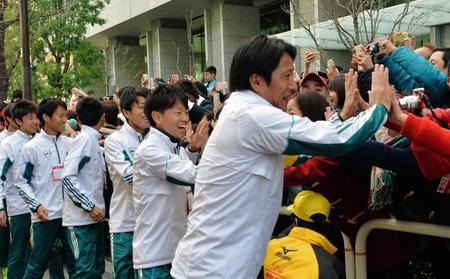 箱根駅伝連覇を決めてファンとタッチをする青学大・原晋監督ら選手たち＝東京・大手町（撮影・佐々木彰尚）