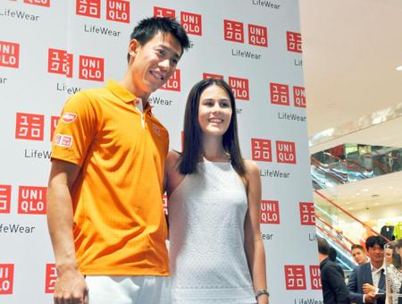 オーストラリア・メルボルンのユニクロ店舗でファンの女性と記念撮影する錦織圭選手（共同）