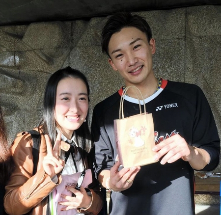 女性ファンにチョコをもらい笑顔の桃田賢斗（右）