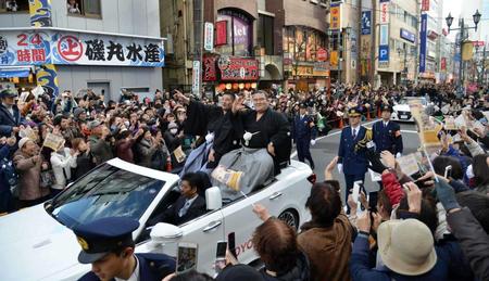 　多くのファンが駅前の沿道を埋め尽くすなか、笑顔で声援に応える琴奨菊（右）と佐渡ケ嶽親方