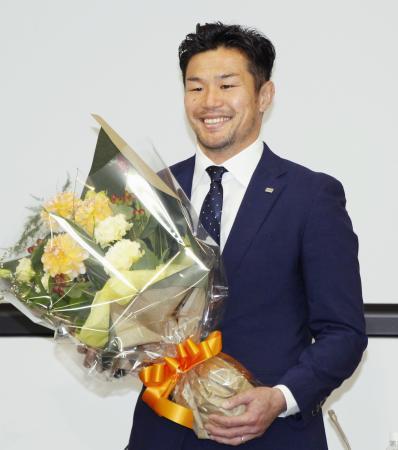 　引退の記者会見で花束を手に笑顔を見せるラグビー元日本代表主将の広瀬俊朗＝１日午後、東京都府中市