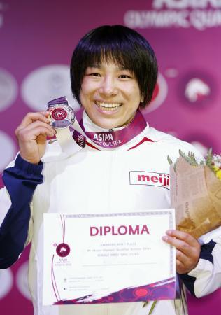 　女子７５キロ級で優勝しメダルを手に笑顔の渡利璃穏＝アスタナ（共同）