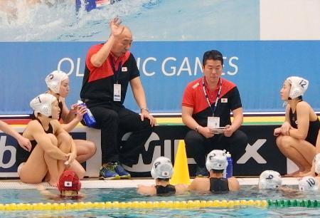 　米国戦で選手に指示を出す、水球女子日本代表の加藤英雄監督（中央左）＝ハウダ（共同）