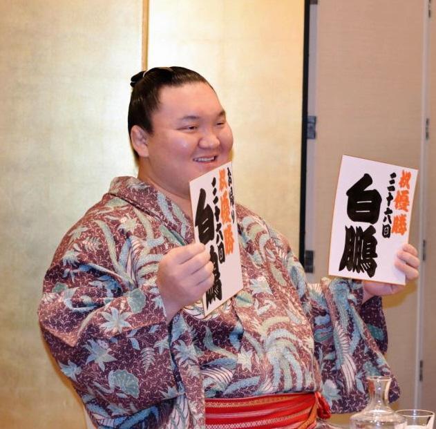 祝優勝三十六回と書かれた色紙を手に笑顔の白鵬