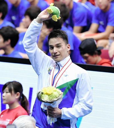 表彰台から笑顔で手を振る松田丈志＝東京辰巳国際水泳場