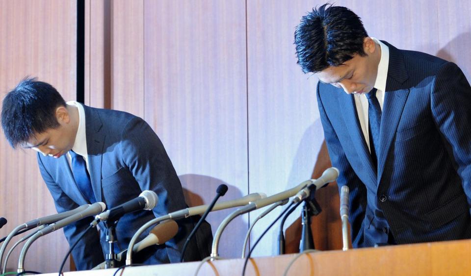 会見の冒頭でそろって頭を下げる田児賢一（左）と桃田賢斗＝東京都内