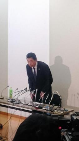 会見で頭を下げる銭谷専務理事＝岸記念体育館