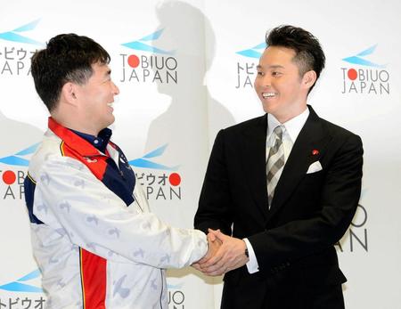 　平井伯昌コーチ（左）と笑顔で握手する北島康介