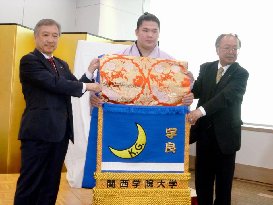 関学大から化粧まわしを贈呈された宇良（中央）。左が同大・村田治学長、右が同大相撲部・永田雄次郎部長