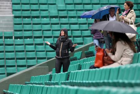 　第９日の全試合が雨天中止となり、センターコートの観客席で空を見上げる女性＝パリ（共同）