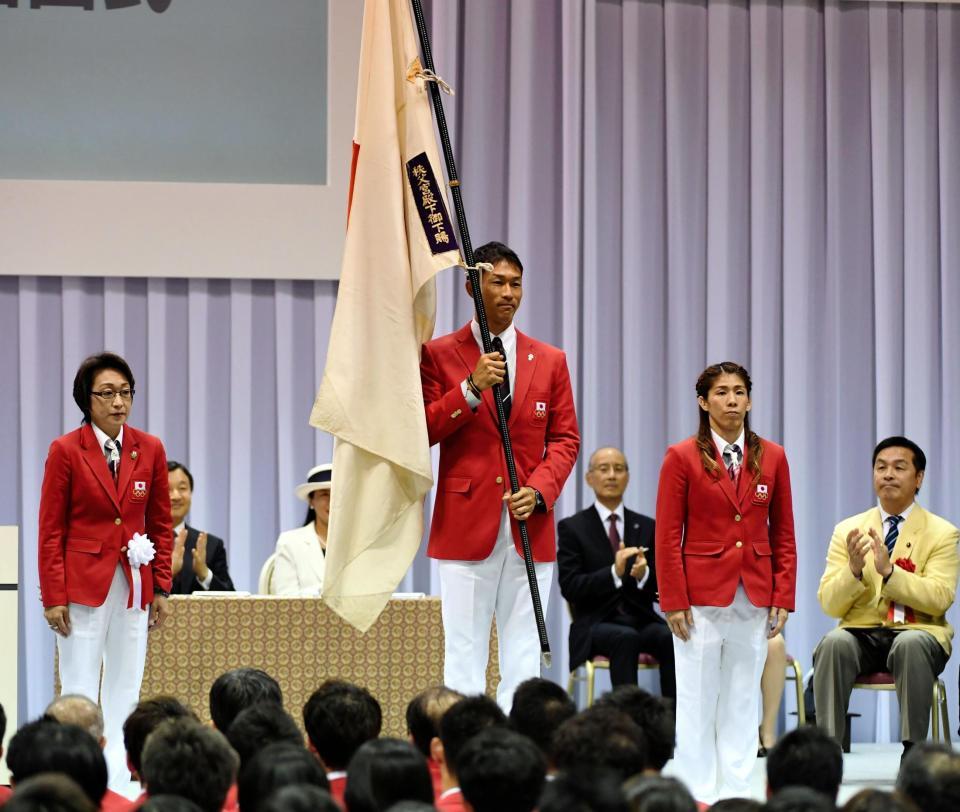 橋本聖子団長（左）から団旗を授かった右代啓祐＝国立代々木競技場（撮影・棚橋慶太）