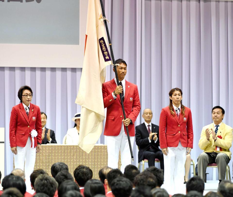 　橋本聖子団長（左）から団旗を授かった右代啓祐と主将の吉田沙保里（撮影・棚橋慶太）