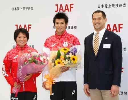 　陸上のリオデジャネイロ五輪代表壮行会で室伏広治さん（右）から花束を贈られた海老原有希女子主将、沢野大地男子主将＝味の素ナショナルトレーニングセンター