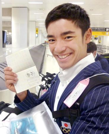 　パスポートに押された大会エンブレムのスタンプに笑顔の体操男子日本代表の白井健三＝２１日、サンパウロ（共同）