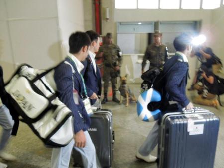 空港に到着し、警備する軍人に驚く白井健三（手前）ら体操男子日本代表チーム＝リオデジャネイロ