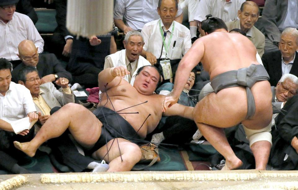 　栃ノ心（右）に渡し込みで敗れ、土俵下に落ちる稀勢の里